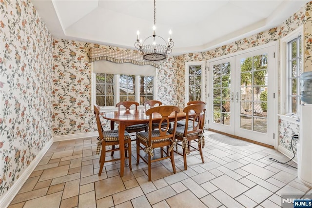 dining room with french doors, a raised ceiling, and a chandelier