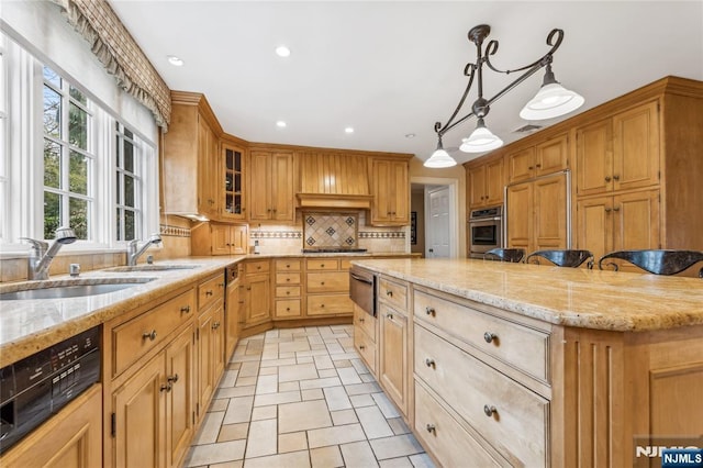 kitchen featuring sink, oven, a kitchen bar, decorative backsplash, and hanging light fixtures