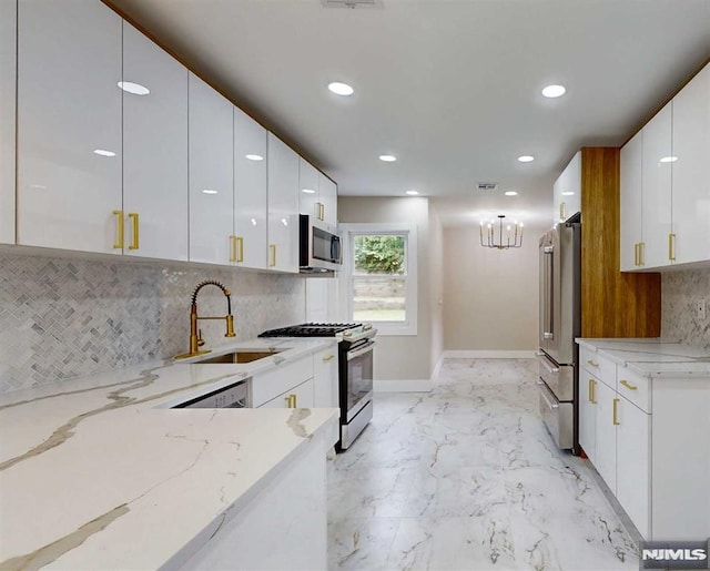 kitchen featuring light stone countertops, sink, white cabinetry, and stainless steel appliances