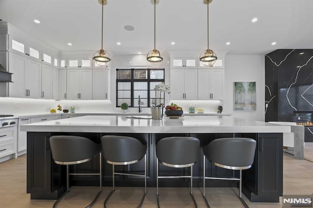 kitchen featuring a spacious island, white cabinetry, and hanging light fixtures