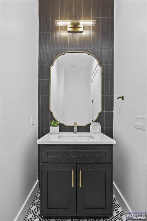 bathroom featuring vanity and tile walls