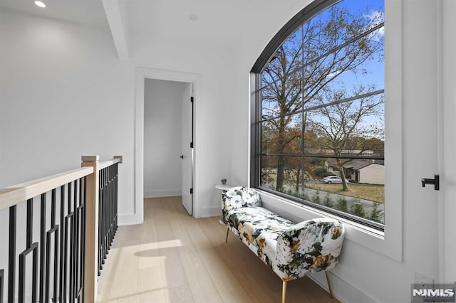 corridor with a water view and light hardwood / wood-style floors