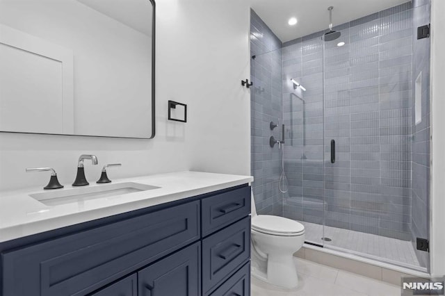 bathroom with tile patterned flooring, vanity, toilet, and a shower with door