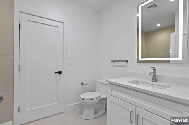 bathroom with tile patterned flooring, vanity, and toilet