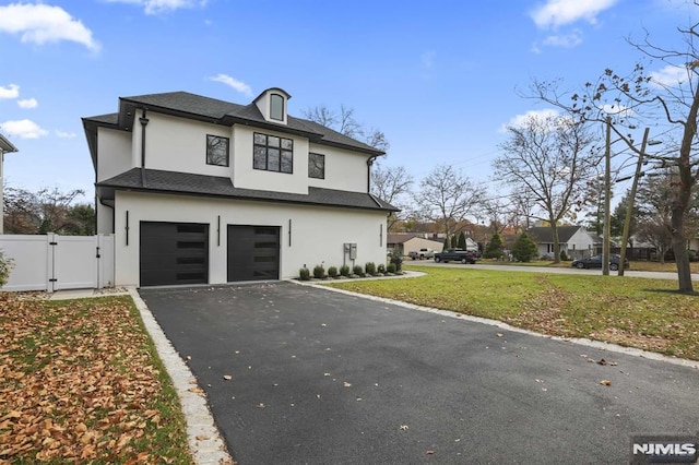 view of front of home with a garage and a front lawn