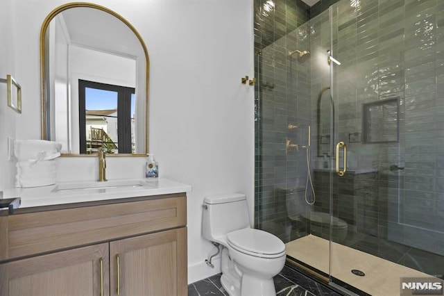 bathroom featuring vanity, toilet, and an enclosed shower