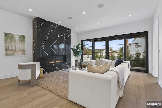 living room with light wood-type flooring and a fireplace