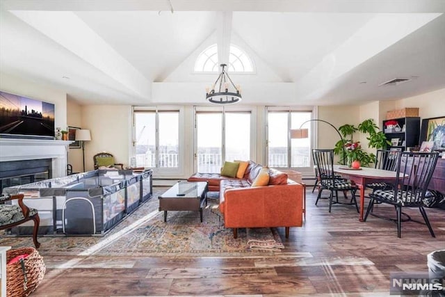 living room featuring a tray ceiling, wood-type flooring, vaulted ceiling, and a baseboard heating unit