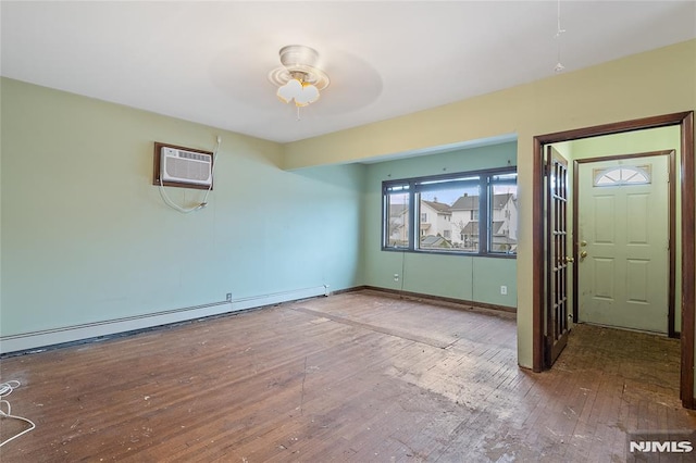 spare room with a wall mounted AC, wood-type flooring, a baseboard radiator, and ceiling fan