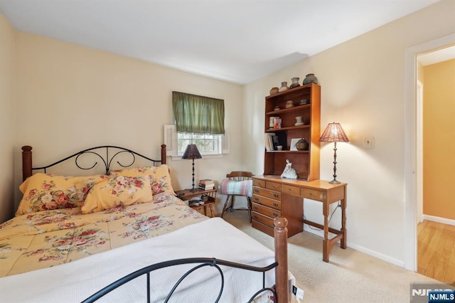 bedroom featuring light colored carpet and baseboards