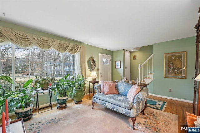 living room with wood finished floors, baseboards, and stairs