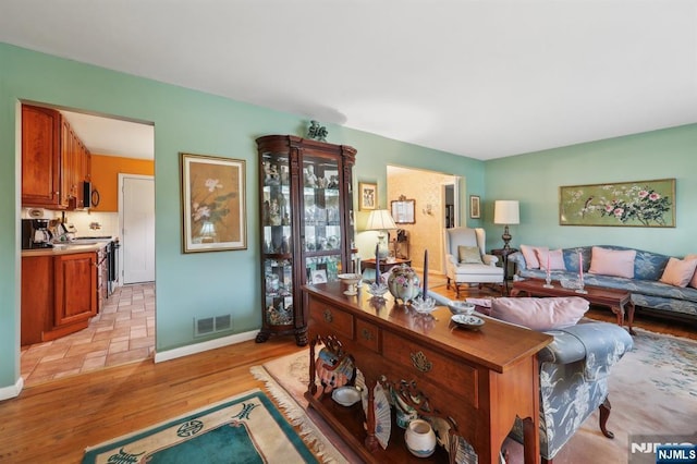 living room featuring baseboards, visible vents, and light wood-style floors