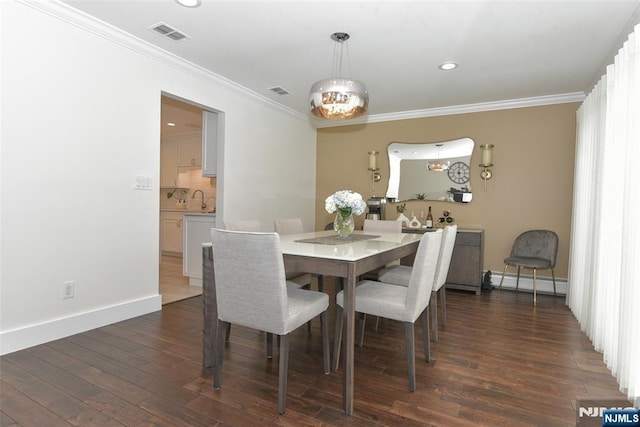 dining room with ornamental molding, a baseboard radiator, dark wood-style flooring, and visible vents