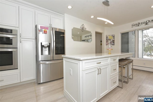 kitchen with white cabinets, stainless steel appliances, light countertops, and a center island