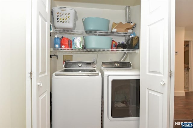 clothes washing area featuring laundry area, separate washer and dryer, and wood finished floors