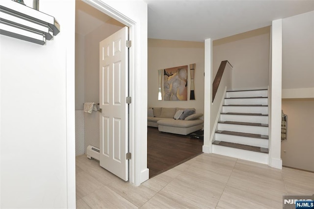 interior space featuring light tile patterned floors, stairs, and baseboard heating