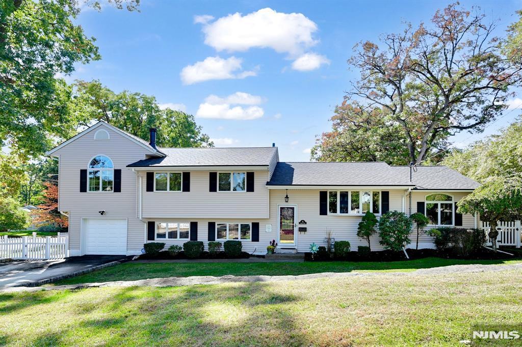 split level home with a garage and a front lawn