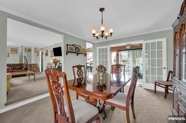 dining space with french doors, light colored carpet, ceiling fan with notable chandelier, and ornamental molding