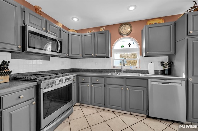 kitchen featuring gray cabinetry, sink, light tile patterned floors, and stainless steel appliances