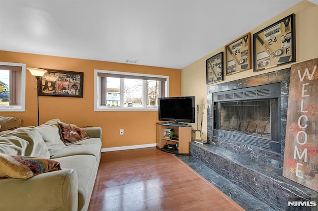 living room featuring a high end fireplace and hardwood / wood-style flooring