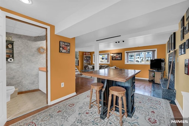 dining area featuring bar area and dark wood-type flooring