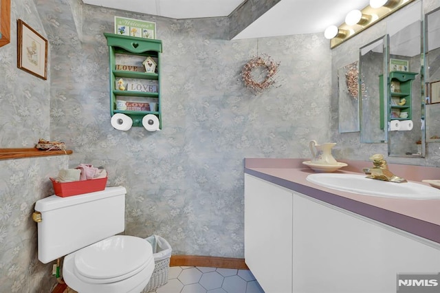 bathroom with tile patterned flooring, vanity, and toilet