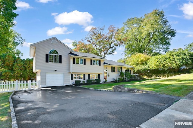 tri-level home featuring a garage and a front lawn