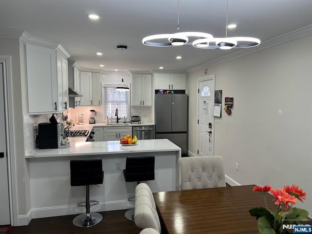 kitchen with stainless steel appliances, white cabinetry, pendant lighting, and kitchen peninsula