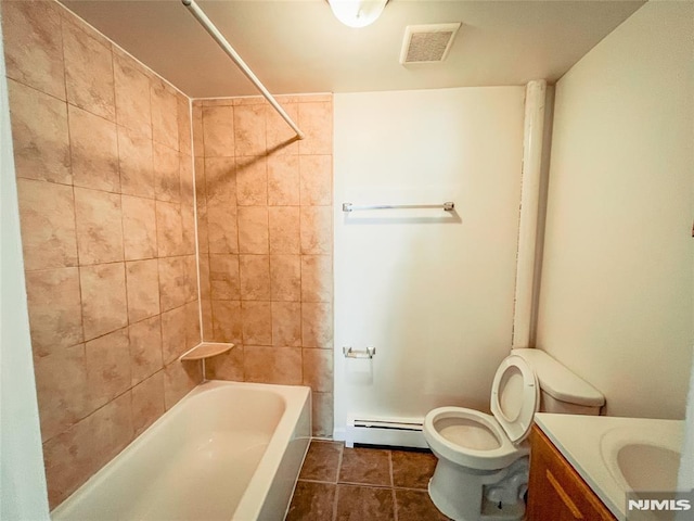 full bathroom with tile patterned floors, vanity, tiled shower / bath combo, baseboard heating, and toilet