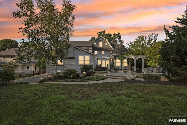 view of front facade featuring a pergola and a lawn