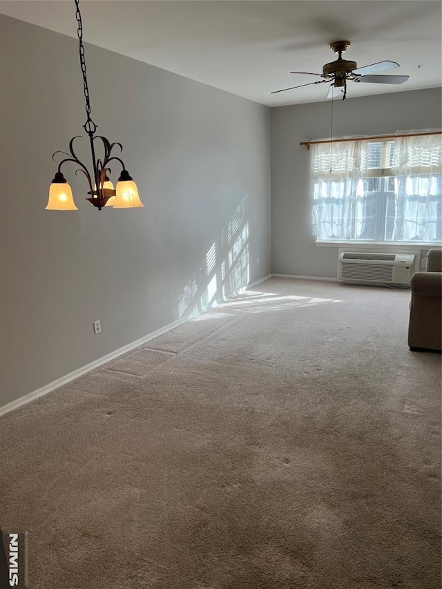 carpeted spare room with an AC wall unit and ceiling fan with notable chandelier