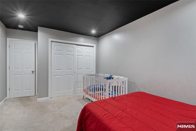 bedroom with light colored carpet and a closet