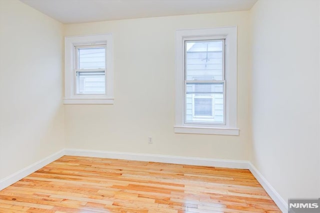 spare room with light wood-type flooring and plenty of natural light