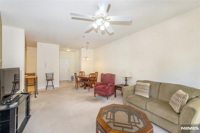 carpeted living room featuring ceiling fan with notable chandelier