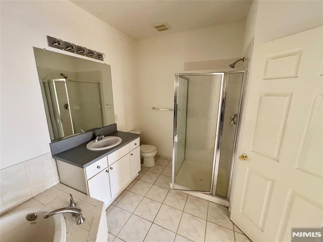 full bathroom featuring tile patterned flooring, vanity, toilet, and independent shower and bath