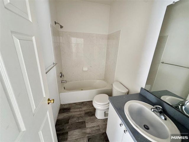 full bathroom with vanity, tiled shower / bath combo, and toilet