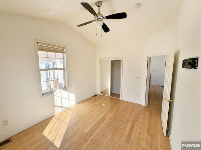 unfurnished bedroom featuring ceiling fan, lofted ceiling, light hardwood / wood-style flooring, and a closet