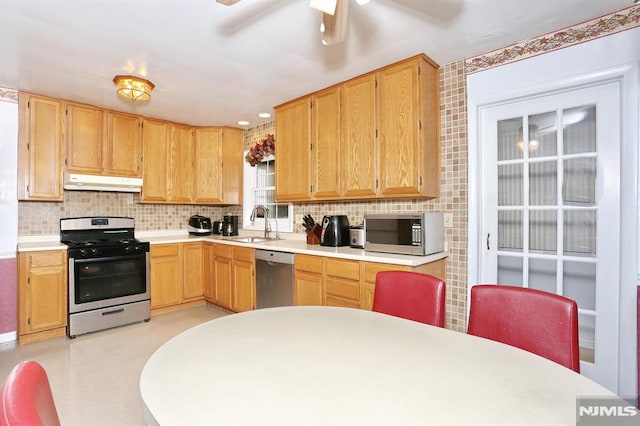 kitchen featuring ceiling fan, stainless steel appliances, tasteful backsplash, light brown cabinetry, and sink