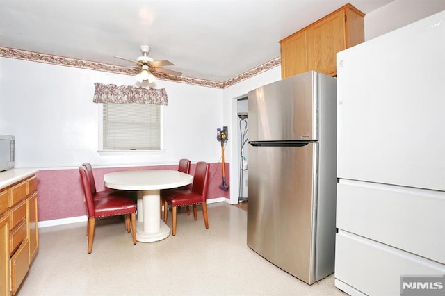 kitchen featuring ceiling fan, stainless steel fridge, and white fridge