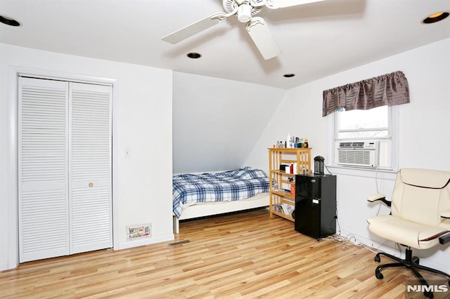 bedroom featuring cooling unit, light hardwood / wood-style floors, a closet, vaulted ceiling, and ceiling fan