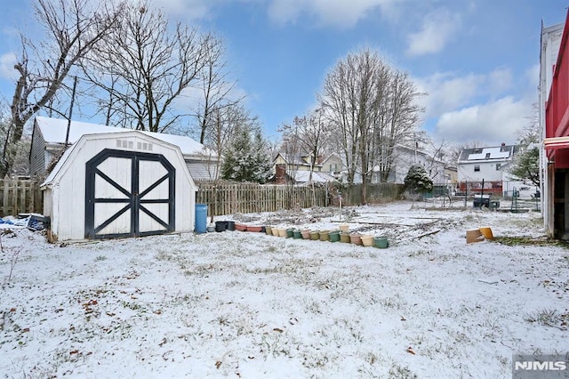 yard layered in snow featuring a shed