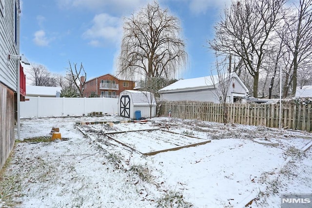 snowy yard featuring a storage unit