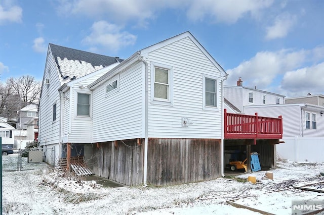 snow covered property featuring central AC and a deck