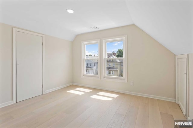 bonus room featuring light hardwood / wood-style floors and vaulted ceiling