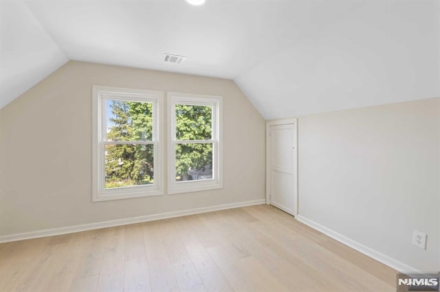 bonus room with light hardwood / wood-style floors and lofted ceiling