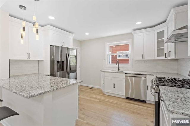 kitchen featuring appliances with stainless steel finishes, white cabinetry, pendant lighting, and sink