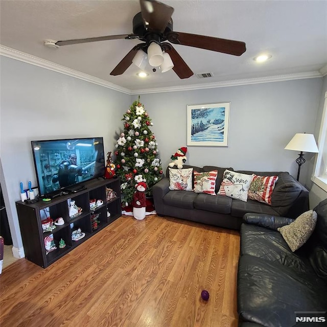 living room with ceiling fan, crown molding, and light hardwood / wood-style flooring