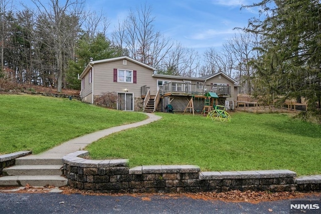 rear view of property featuring a yard and a wooden deck