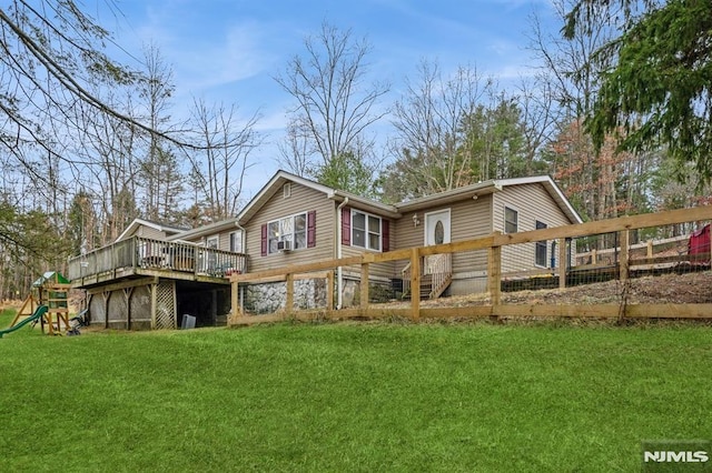 rear view of house with a lawn and a deck