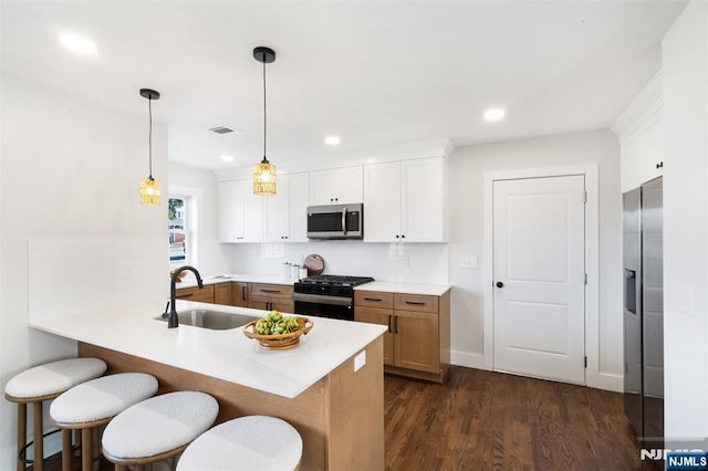 kitchen with white cabinetry, hanging light fixtures, stainless steel appliances, and kitchen peninsula